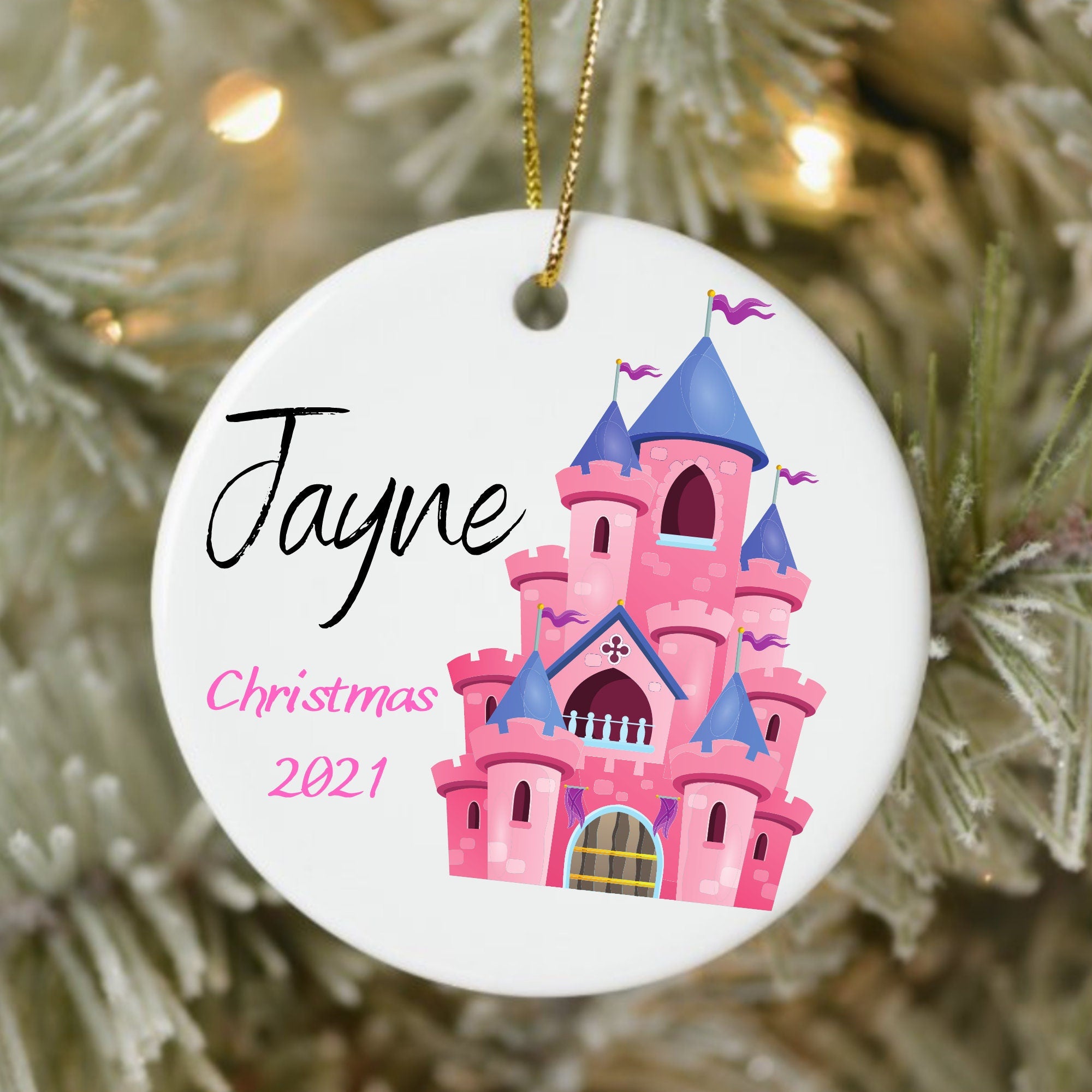 Christmas ornament with pink castle design and 'Jayne Christmas 2021' text on a tree.