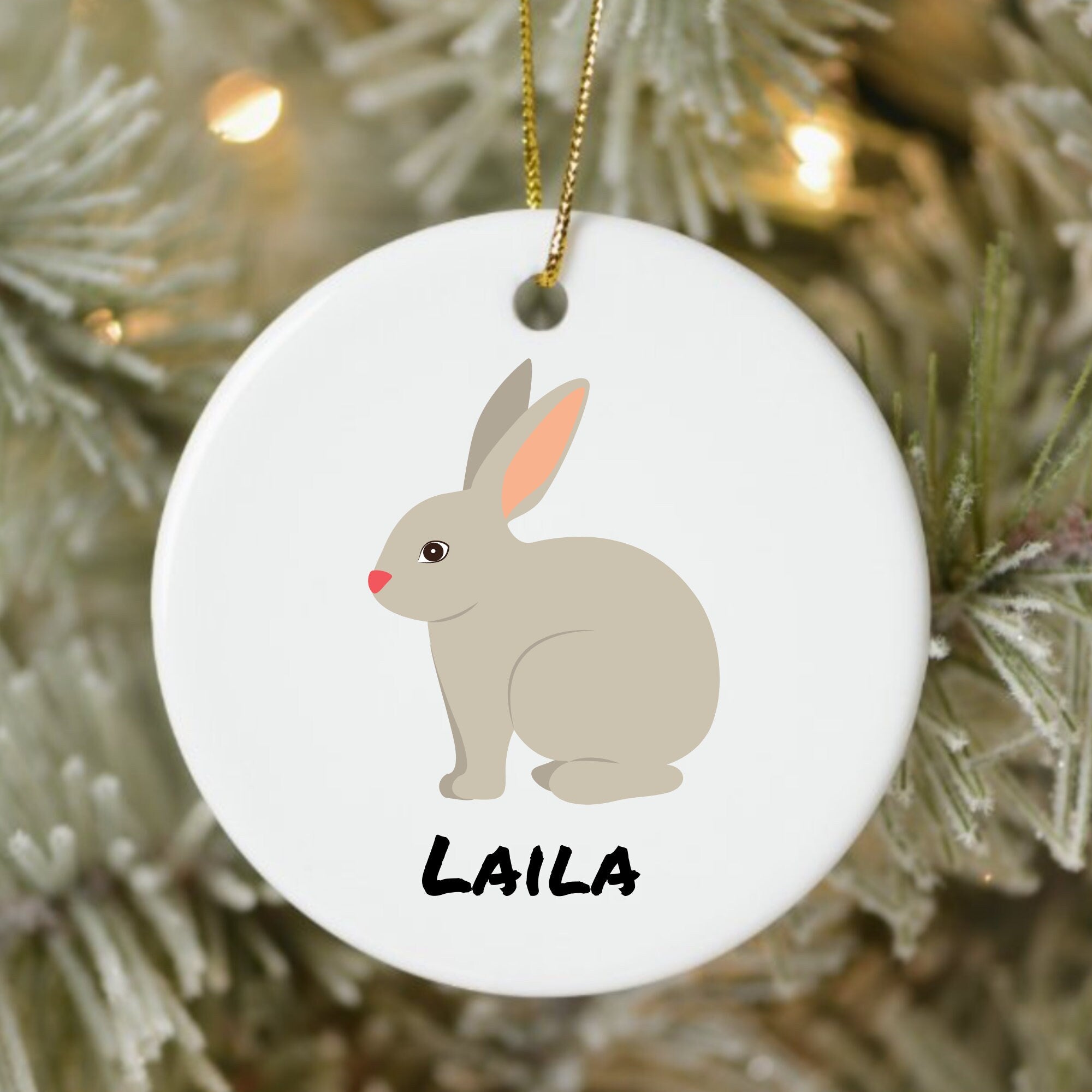 Decorative ornament with a rabbit illustration and 'LAILA' text, hanging on a Christmas tree.
